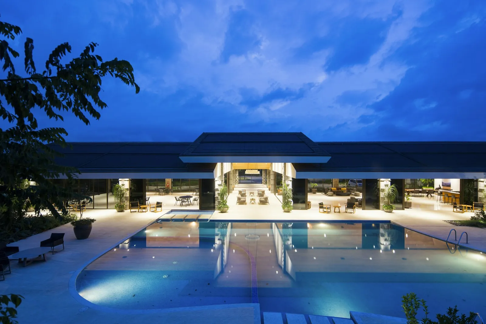 Gece aydınlatılmış otel girişi ve havuz