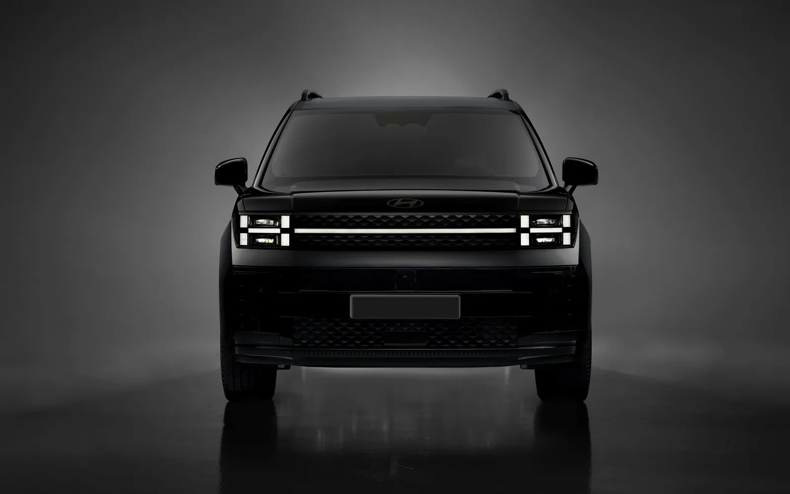 Stüdyoda önden görünen siyah SUV, LED farlar yanık